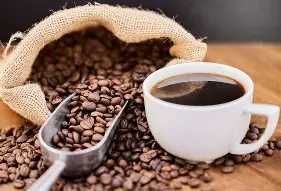 Fresh organic coffee beans and freshly brewed dark coffee
